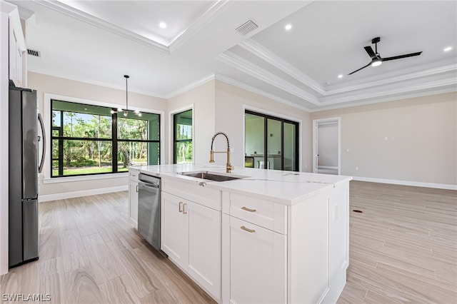 kitchen with light stone countertops, a center island with sink, sink, white cabinets, and appliances with stainless steel finishes