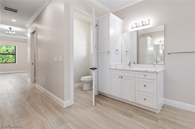 bathroom with vanity, toilet, and ornamental molding