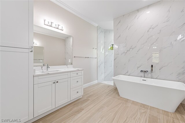 bathroom with tile walls, a bathtub, ornamental molding, and vanity