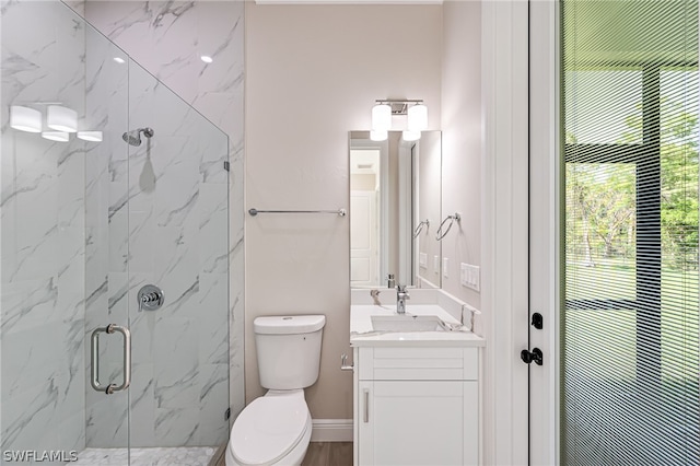 bathroom featuring a shower with door, large vanity, and toilet