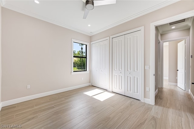 unfurnished bedroom with two closets, ceiling fan, crown molding, and light wood-type flooring