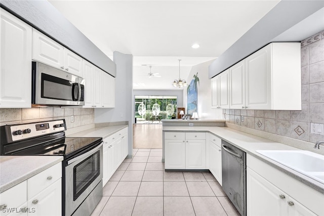 kitchen featuring pendant lighting, ceiling fan, appliances with stainless steel finishes, light tile patterned flooring, and white cabinetry