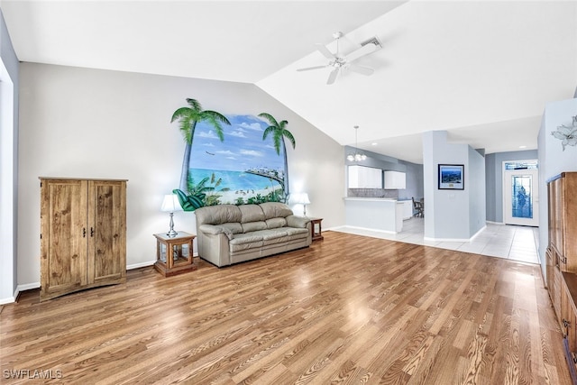 living room with lofted ceiling, ceiling fan, and wood-type flooring