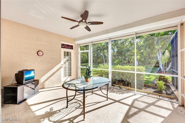 unfurnished sunroom featuring ceiling fan