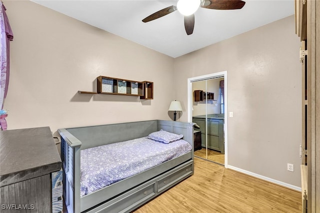 bedroom featuring ceiling fan, a closet, and light wood-type flooring