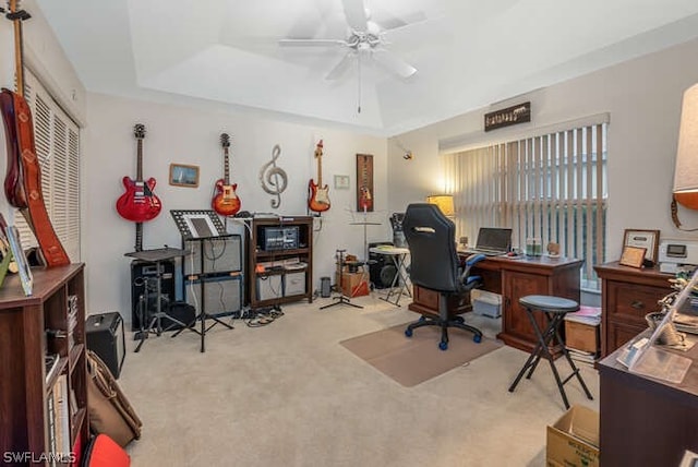 home office featuring ceiling fan, a raised ceiling, and light colored carpet