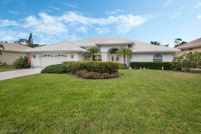 view of front of house with a garage and a front lawn