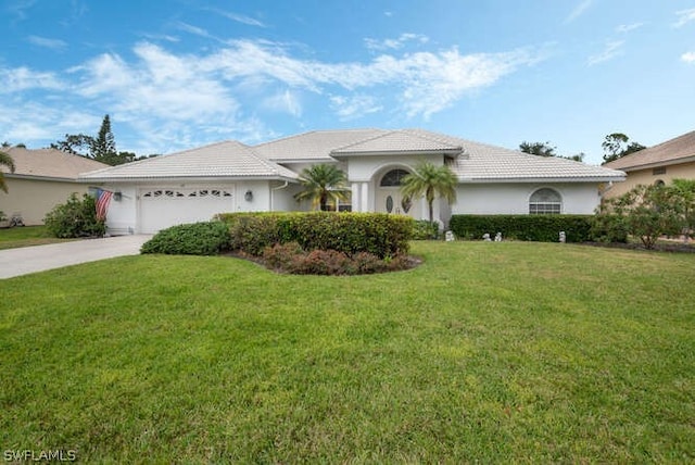 view of front of house featuring driveway, an attached garage, a tile roof, and a front yard