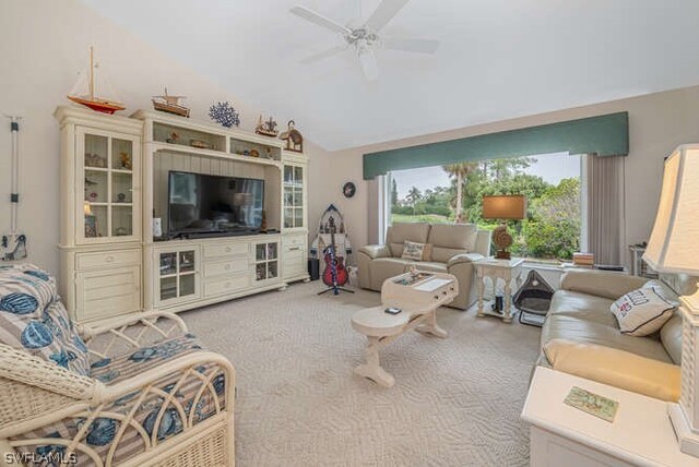 carpeted living room with ceiling fan and lofted ceiling