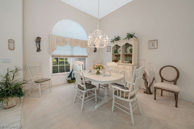 dining room with a towering ceiling, light colored carpet, and an inviting chandelier