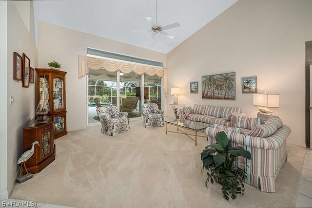 living area with ceiling fan, high vaulted ceiling, and light colored carpet