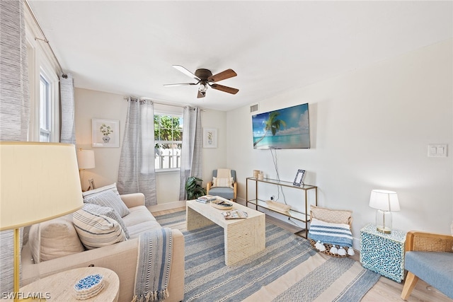 living room with light hardwood / wood-style floors and ceiling fan