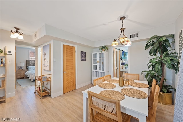 dining room with a chandelier and light hardwood / wood-style flooring