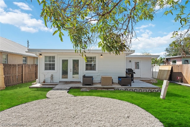 rear view of house with french doors, a yard, and a patio