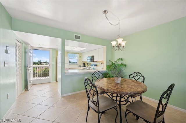 dining space featuring a notable chandelier and light tile floors