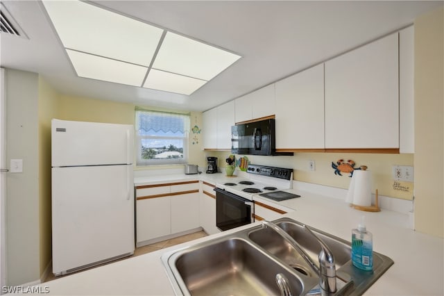 kitchen featuring white appliances, sink, light tile flooring, and white cabinetry