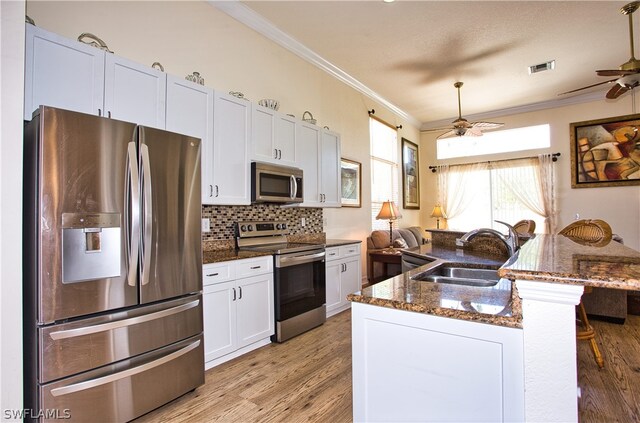 kitchen featuring white cabinets, sink, dark stone countertops, light wood-type flooring, and stainless steel appliances