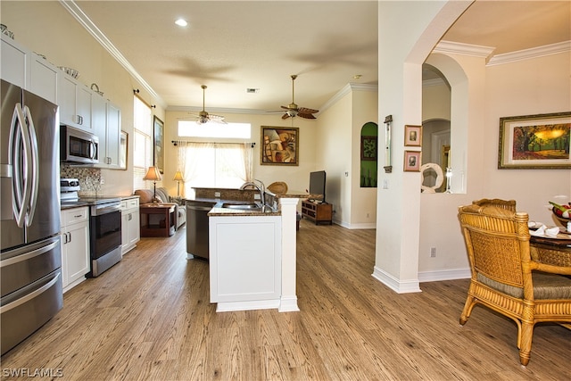 kitchen featuring sink, light hardwood / wood-style flooring, appliances with stainless steel finishes, a kitchen island with sink, and white cabinets