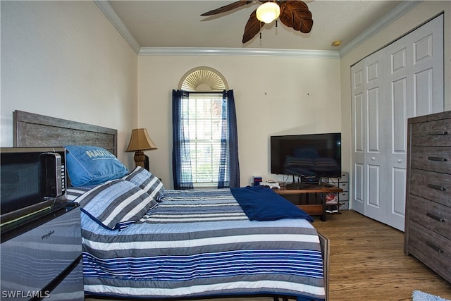 bedroom featuring hardwood / wood-style flooring, ornamental molding, a closet, and ceiling fan