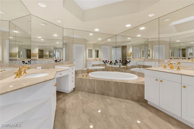 bathroom with two vanities, a bath, marble finish floor, and a sink