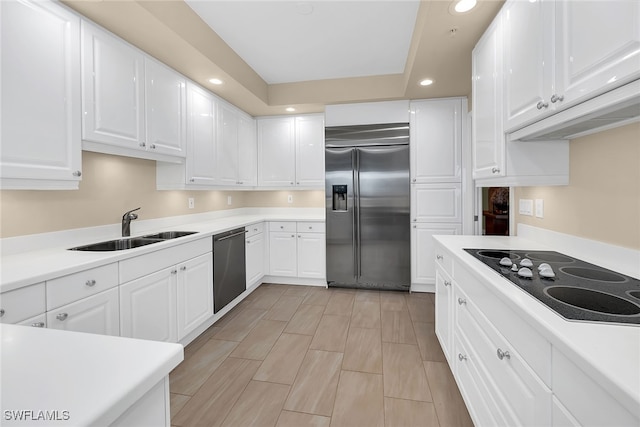 kitchen with light wood-type flooring, white cabinets, appliances with stainless steel finishes, and sink