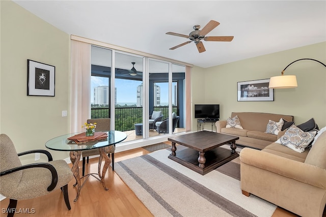 living area with light wood finished floors, floor to ceiling windows, and ceiling fan