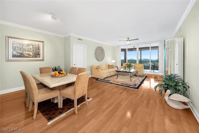 dining room with visible vents, baseboards, light wood-type flooring, ornamental molding, and a ceiling fan