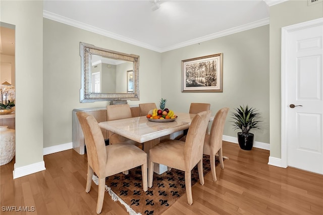 dining space with light wood-style flooring, baseboards, and ornamental molding