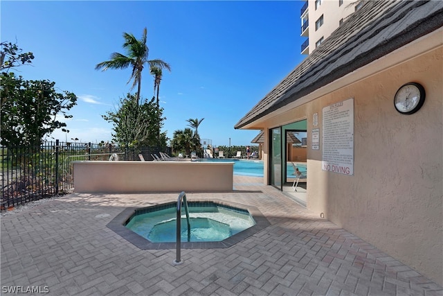 view of pool featuring a hot tub and a patio area