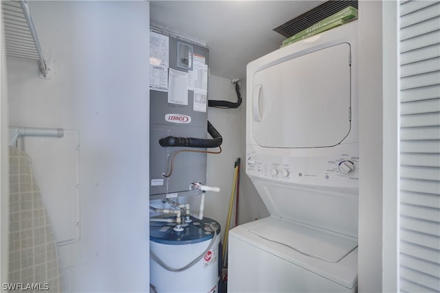 clothes washing area with stacked washer and clothes dryer and water heater