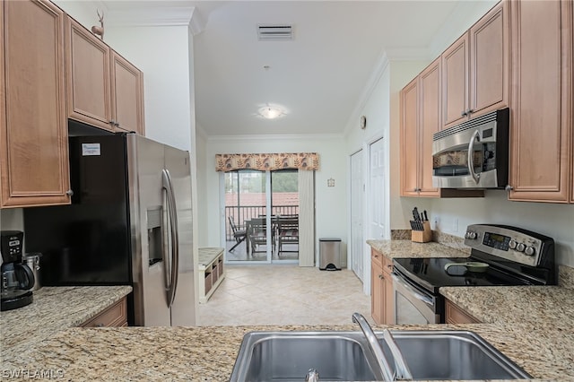 kitchen featuring light stone counters, ornamental molding, appliances with stainless steel finishes, sink, and light tile floors