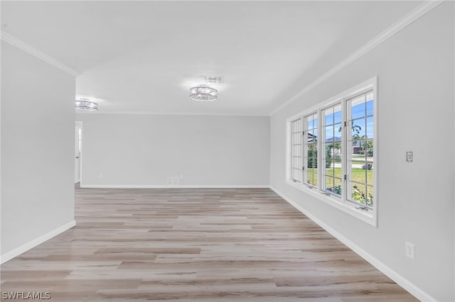 empty room with crown molding and light hardwood / wood-style floors