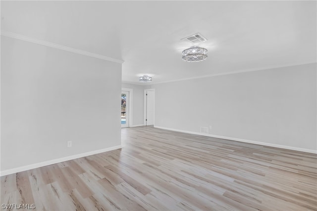 spare room with ornamental molding and light hardwood / wood-style floors