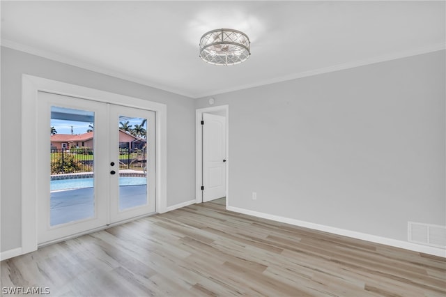 unfurnished room with french doors, crown molding, and light hardwood / wood-style floors