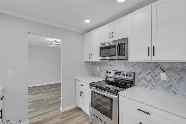 kitchen featuring backsplash, appliances with stainless steel finishes, light wood-type flooring, white cabinets, and light stone counters