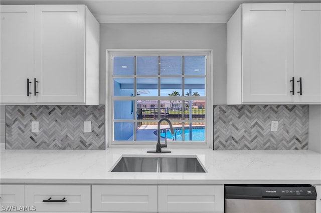 kitchen featuring white cabinets, backsplash, dishwasher, and light stone counters