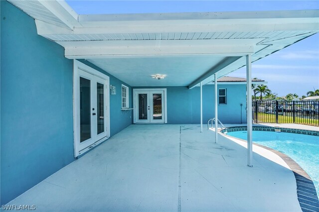 view of swimming pool with french doors and a patio