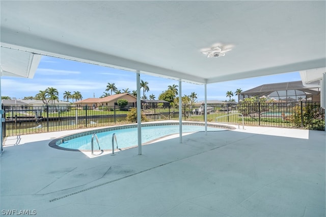 view of pool with glass enclosure and a patio area