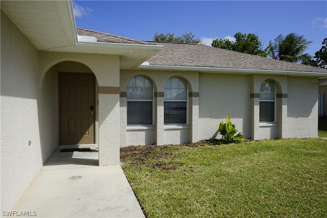 entrance to property with a lawn