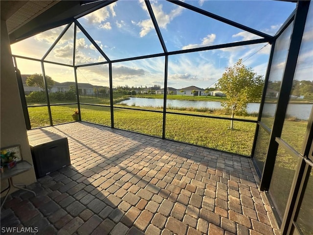 view of patio / terrace featuring glass enclosure and a water view