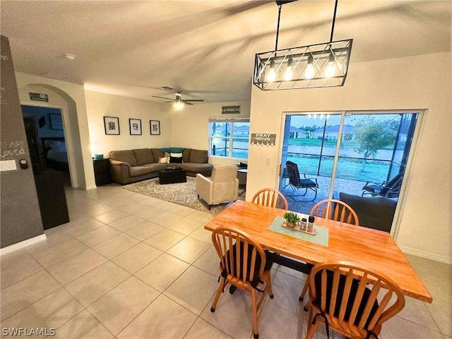 dining area with light tile patterned floors and ceiling fan with notable chandelier