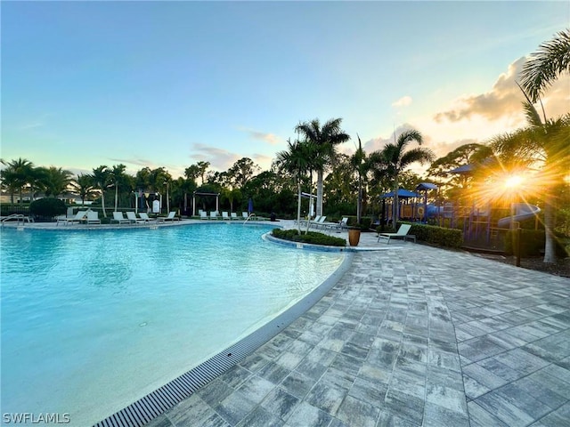 pool at dusk with a patio