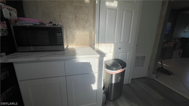 clothes washing area with hardwood / wood-style flooring