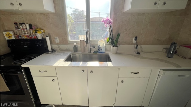 kitchen featuring black electric range oven, light stone countertops, white cabinetry, white dishwasher, and sink