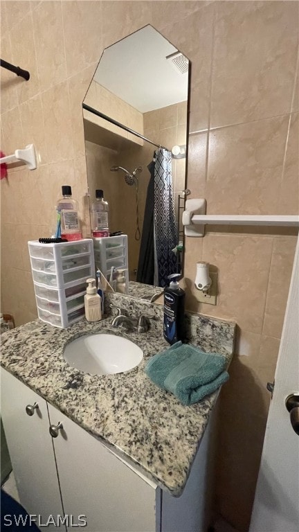 bathroom with vanity and tile walls