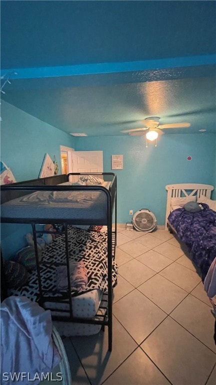 tiled bedroom featuring ceiling fan