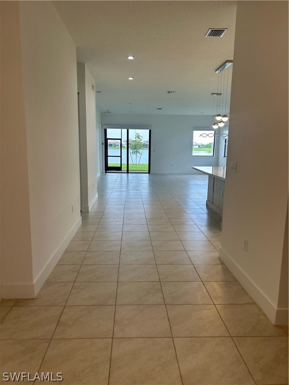 corridor featuring a healthy amount of sunlight and light tile floors