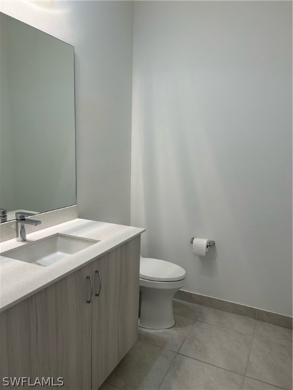 bathroom with tile flooring, toilet, and vanity