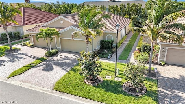 mediterranean / spanish-style home with a front yard and a garage