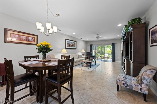 tiled dining area with ceiling fan with notable chandelier